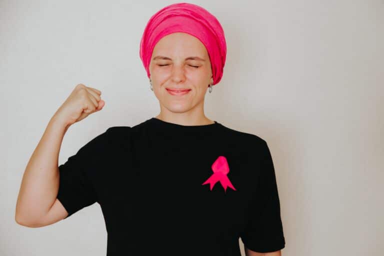 woman-smiling-with-pink-ribbon-on-black-shirt-2026-03-17-06-27-46-utc (1)